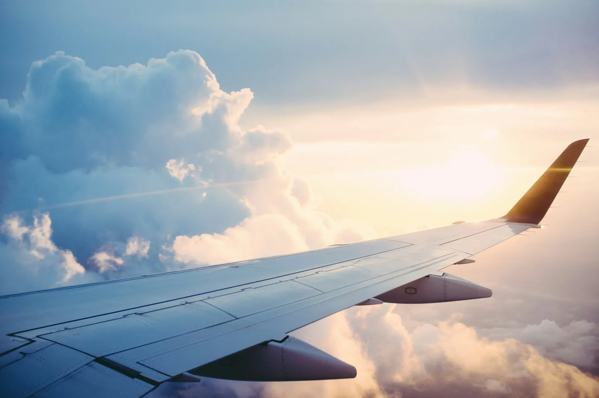 Ala de un avión comercial sobre las nubes al atardecer