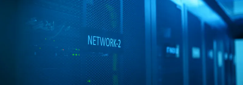 Pasillo de racks de servidores iluminado en azul dentro de un datacenter